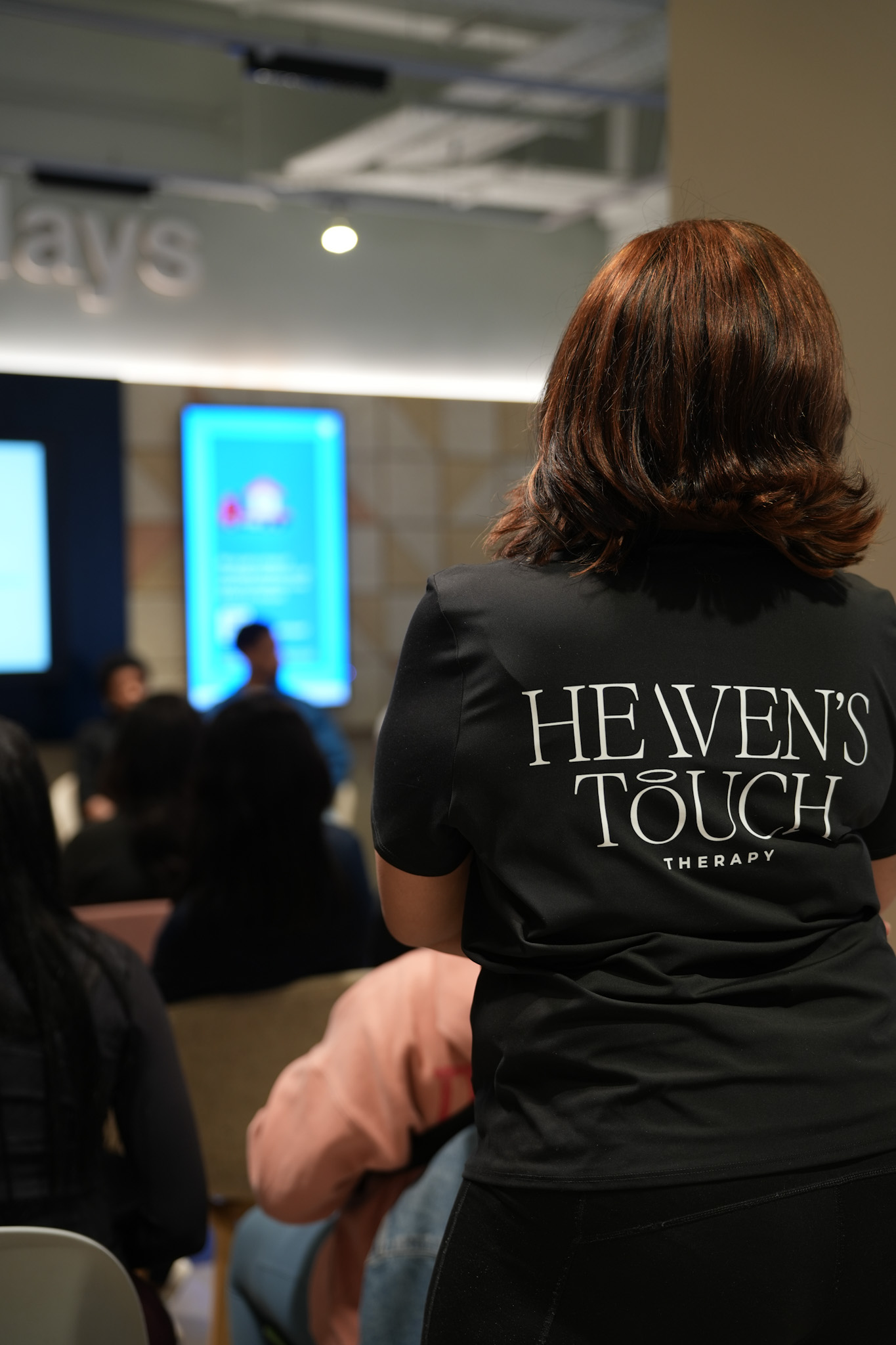 Heaven's Touch Therapy team member in branded polo at the Come As You Are wellness event at Barclays